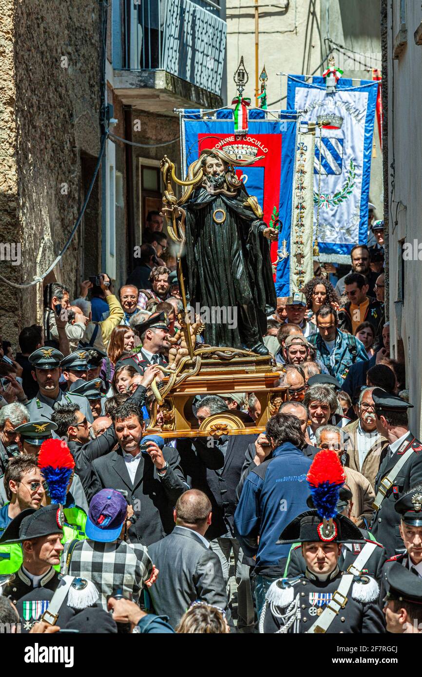 The statue of San Domenico, with snakes on it, carried in procession through the streets of the Borgo between banners and a devout crowd. Cocullo, Abr Stock Photo