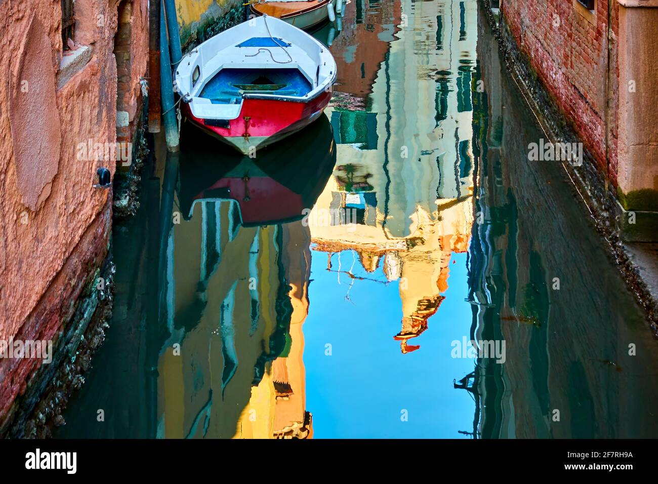 Canal with boat in Venice and water reflection, Italy Stock Photo - Alamy