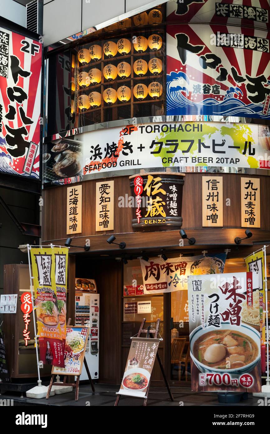 Vertical view of a bar restaurant façade plenty of advertising on Shibuya Center-gai, Shibuya, Tokyo, Japan Stock Photo