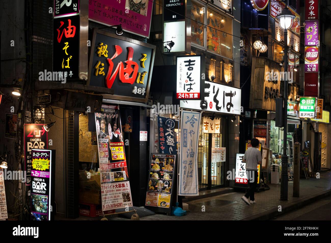 Horizontal night view of a row of bars and restaurants plenty of flashy neon signs on Shibuya Center-gai, Shibuya, Tokyo, Japan Stock Photo