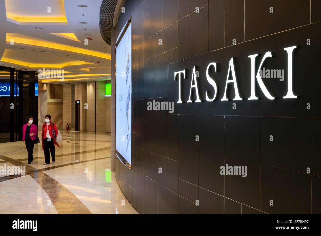 Shoppers walk past the Japanese jewellery producer and luxury brand Tasaki store in Hong Kong