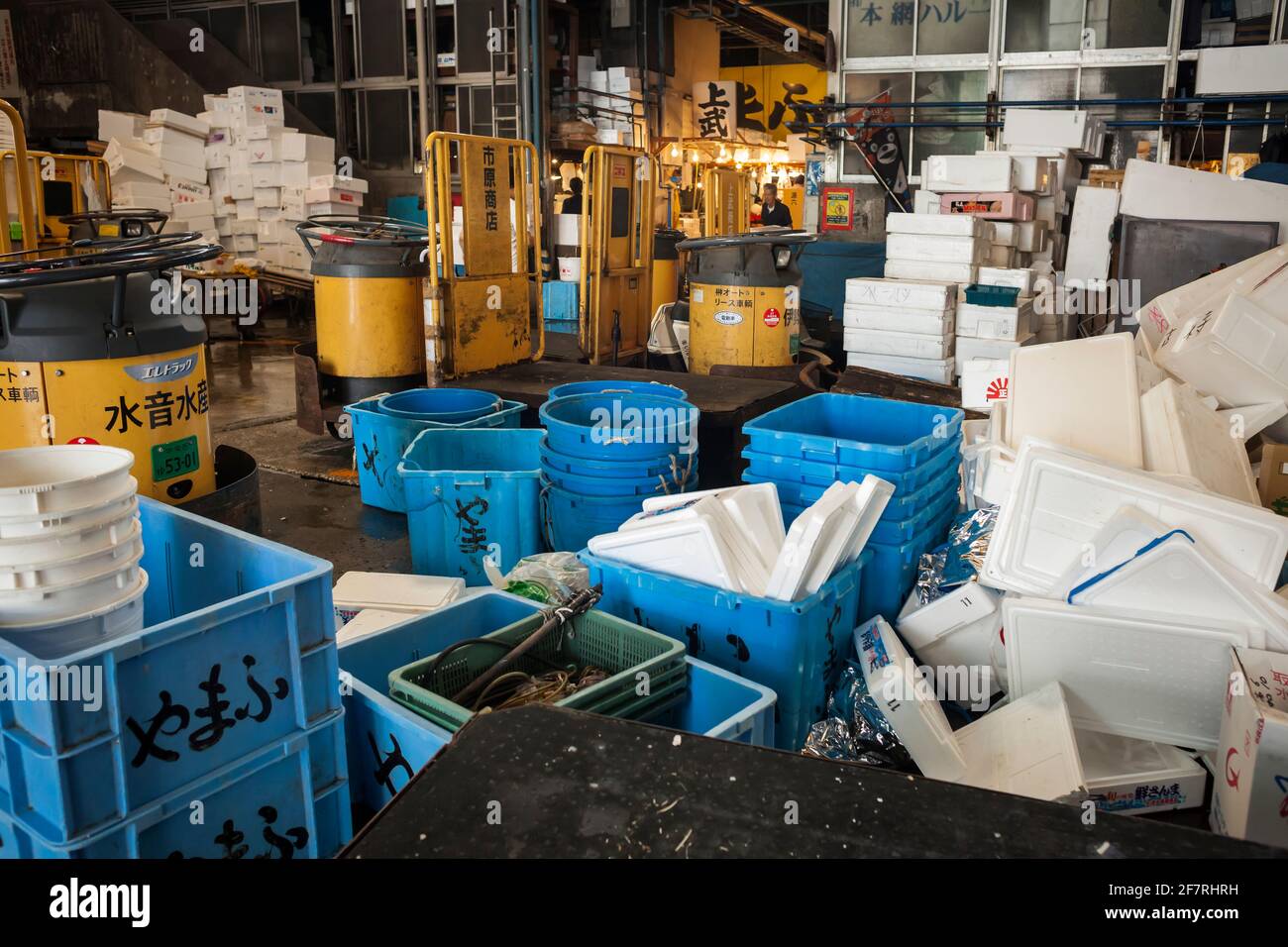 Lots of isothermal boxes, buckets and parked fork lift trucks in the loading and unloading zone of the Tokyo's Tsukiji inner fish market, Tokyo, Japan Stock Photo