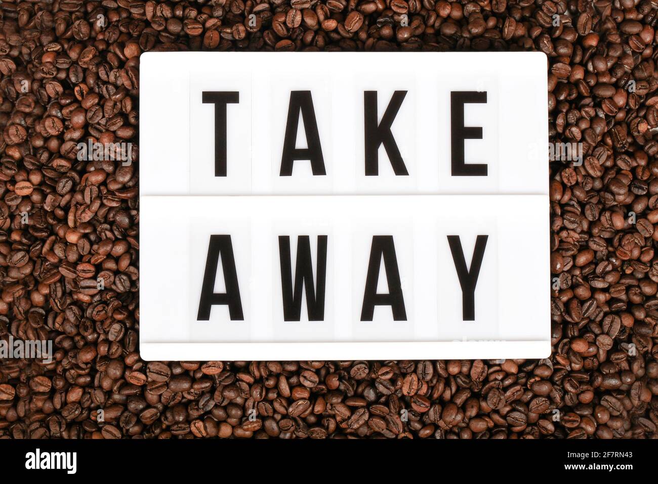light box with text take away among the coffee beans , reopening, online, delivery concept Stock Photo