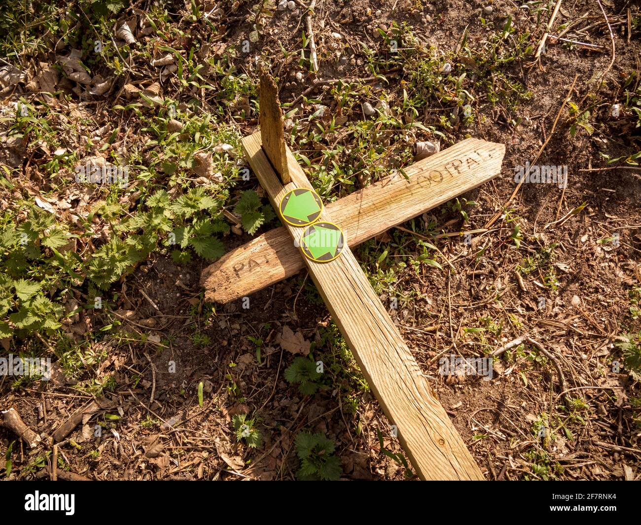 A broken footpath sign in the country laying on the ground Stock Photo