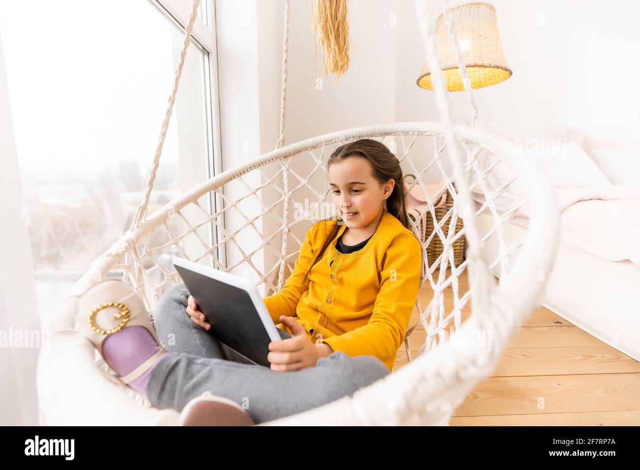 Cute girl lying on sofa with tablet computer Stock Photo - Alamy