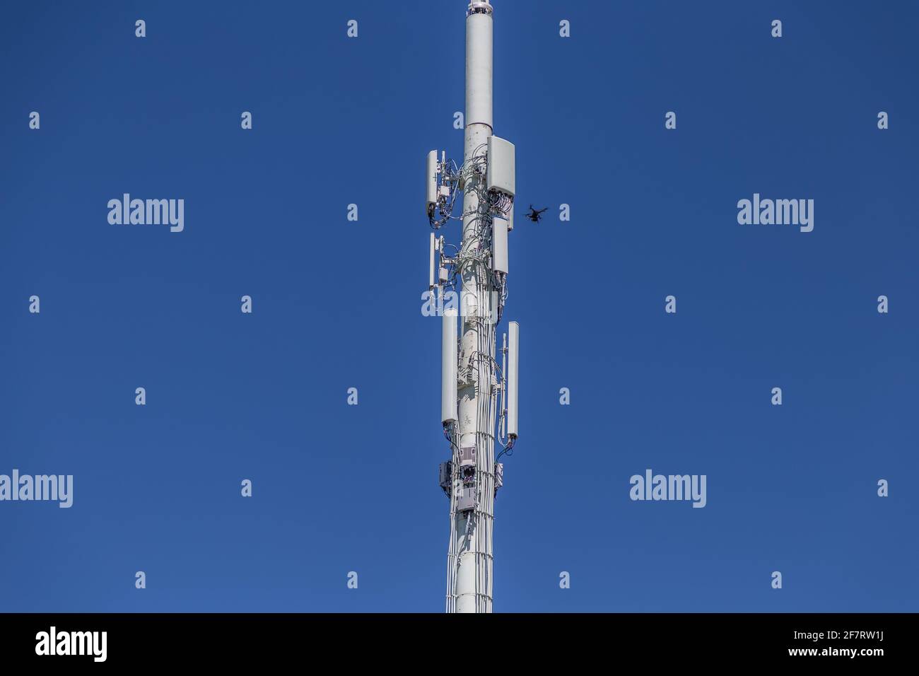 Drone Inspecting upper right of a cell tower Stock Photo