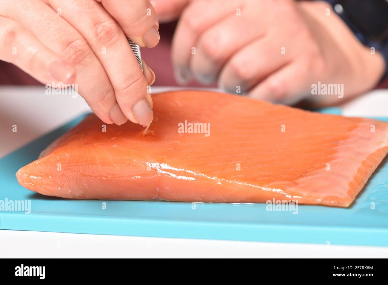 Chef pull out bones in red fish with tweezers Stock Photo