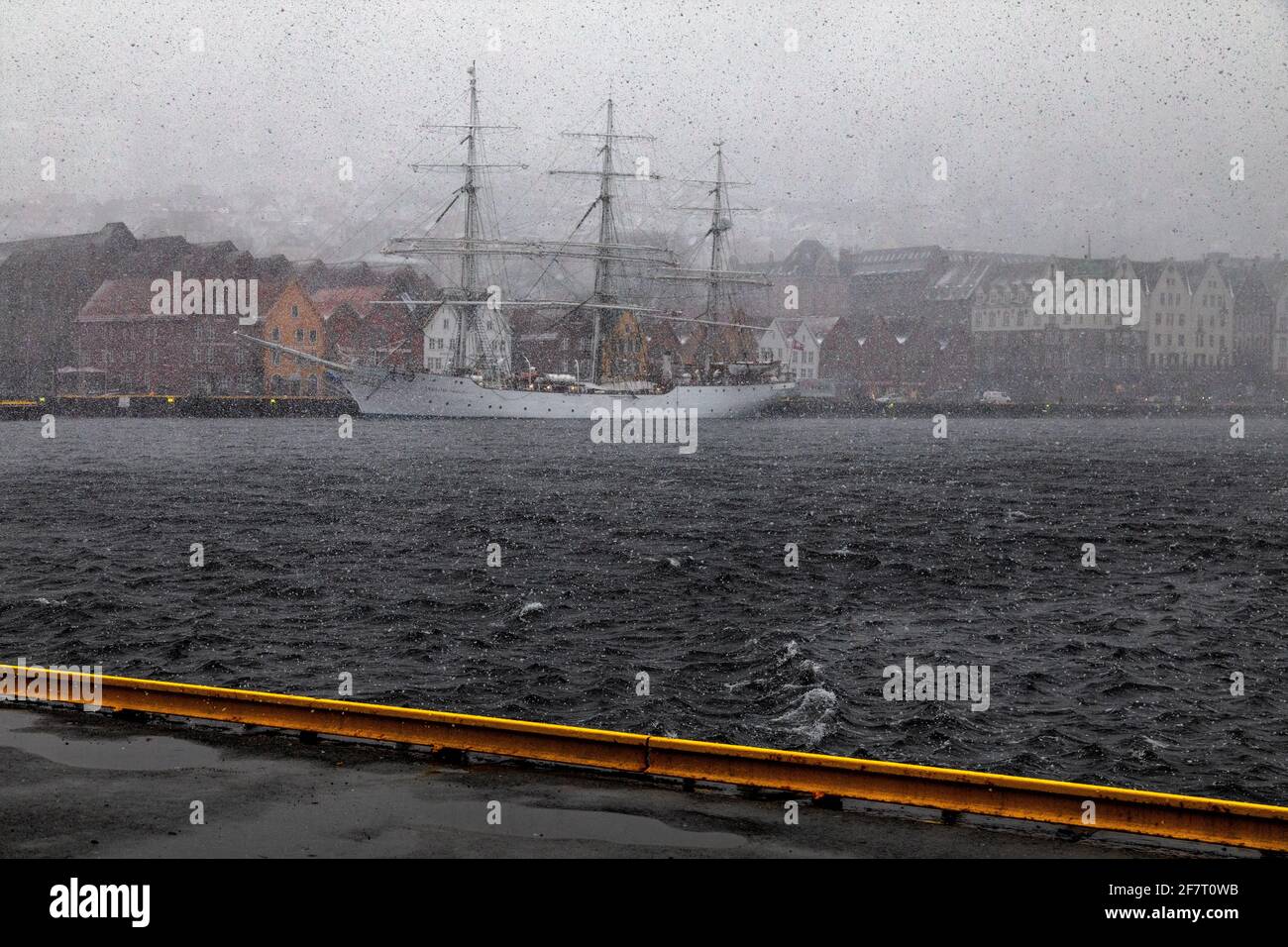 Full-rigged sail ship Christian Radich (built 1937) in a snow storm. At Bryggen quay, in the old port of Bergen, Norway. Stock Photo