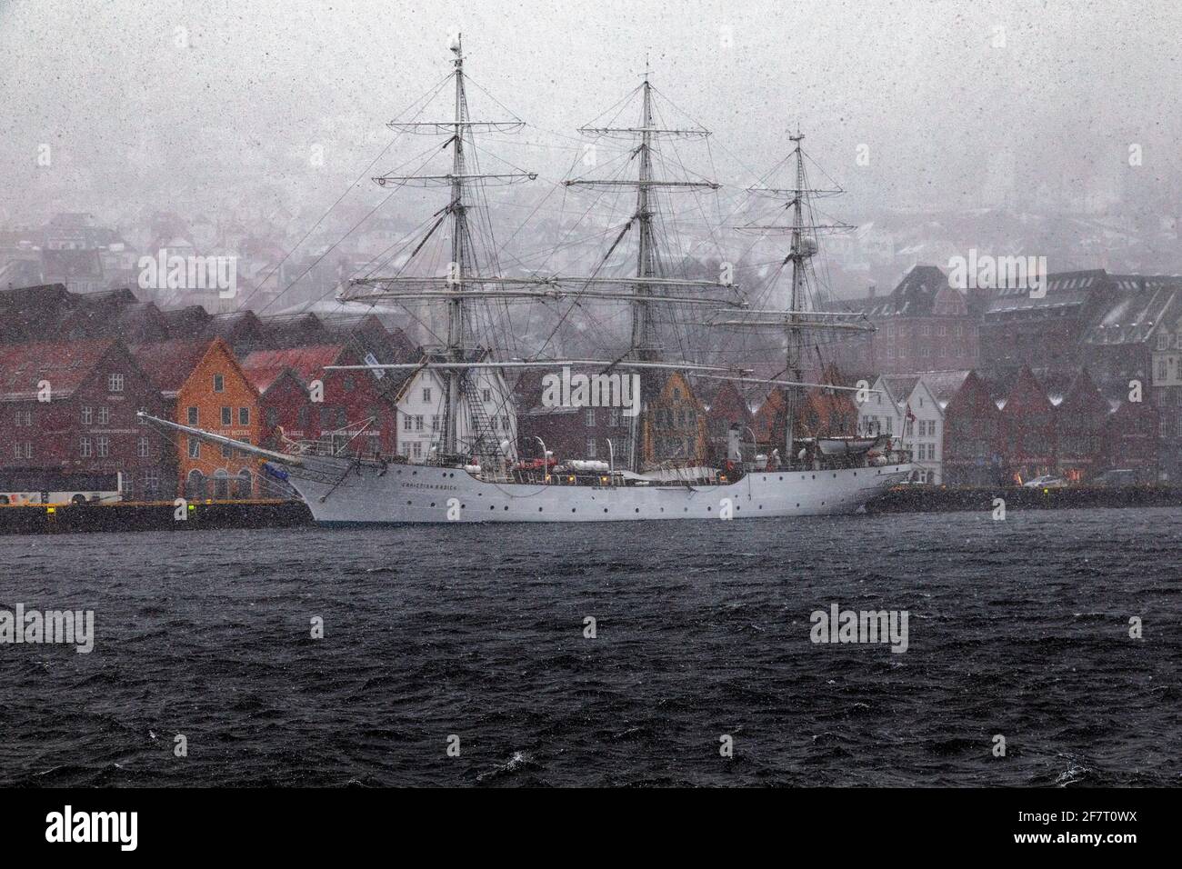 Full-rigged sail ship Christian Radich (built 1937) in a snow storm. At Bryggen quay, in the old port of Bergen, Norway. Stock Photo