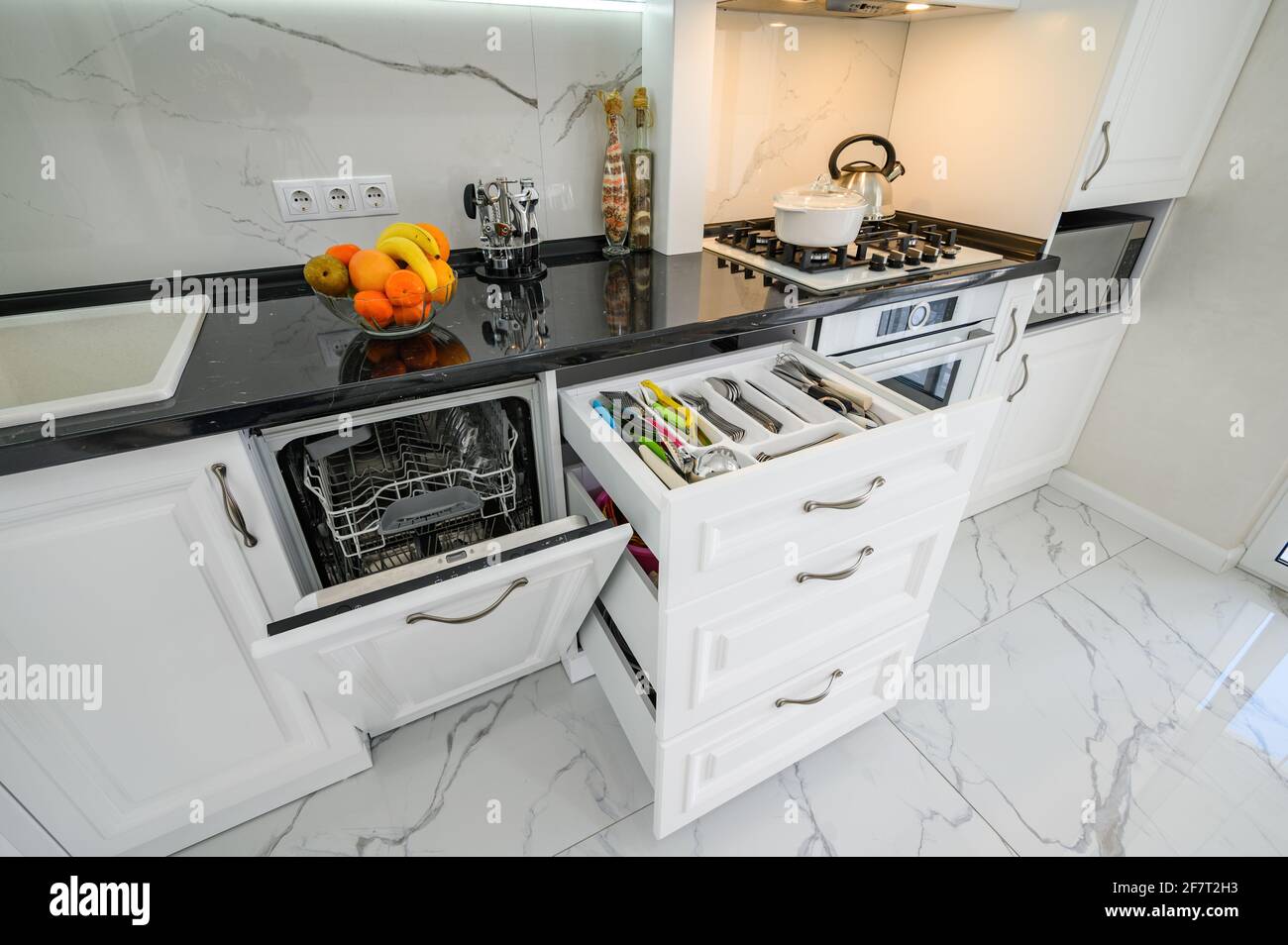 Luxurious white modern kitchen interior, drawers pulled out, dishwasher
