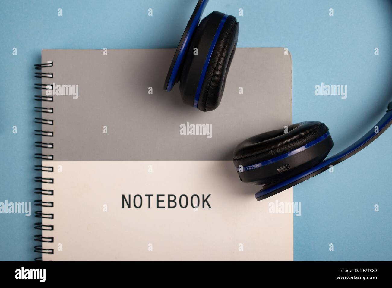 Notebook and headphones on a blue surface Stock Photo
