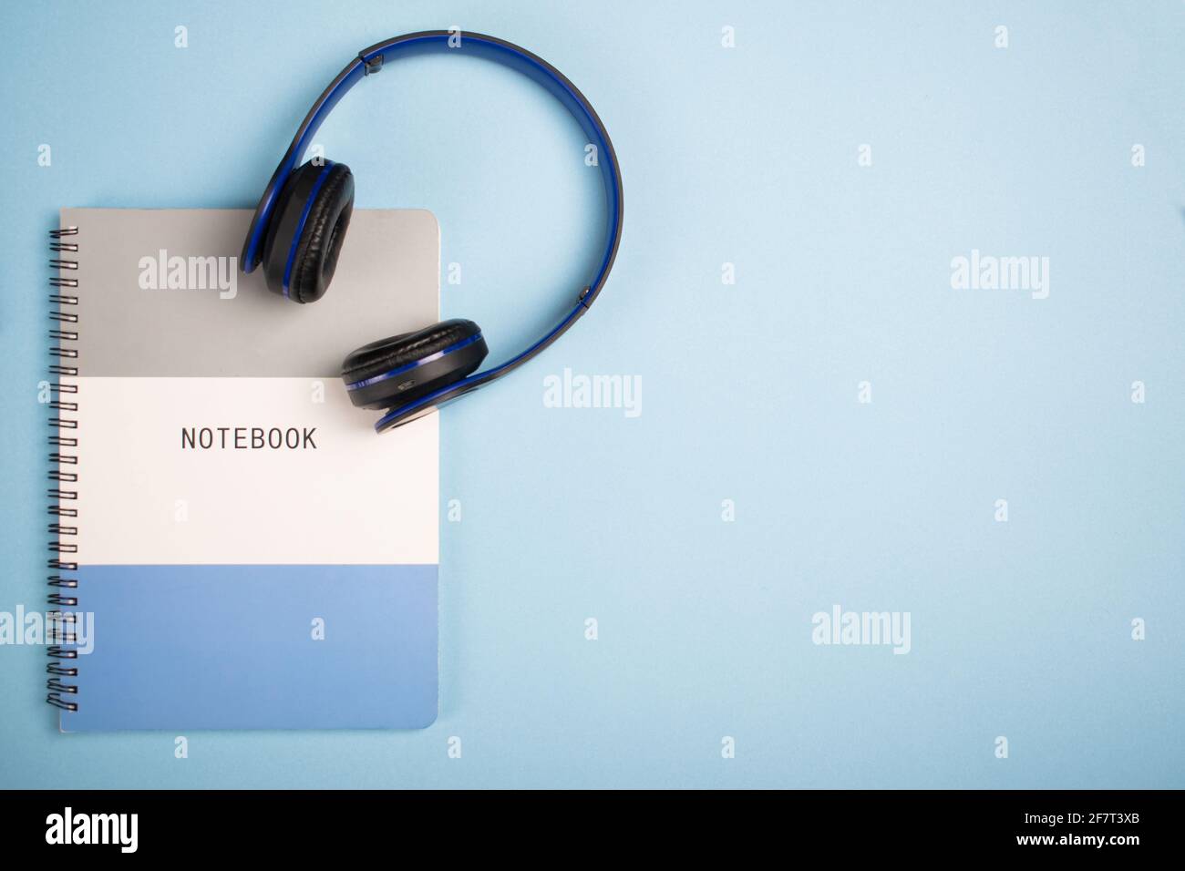 Notebook and headphones on a blue surface - copy space Stock Photo