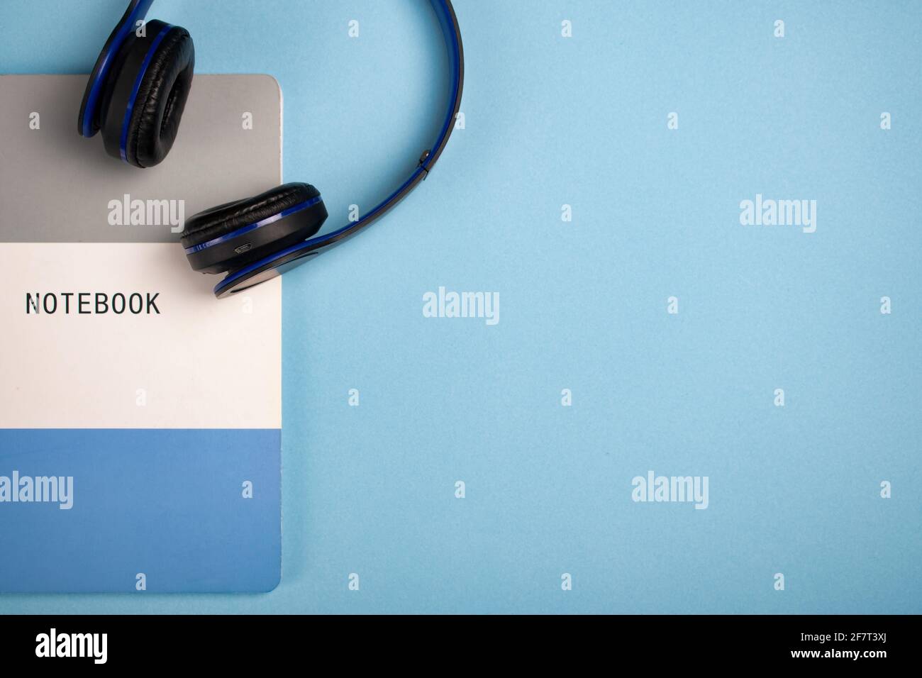 Notebook and headphones on a blue surface - copy spac Stock Photo