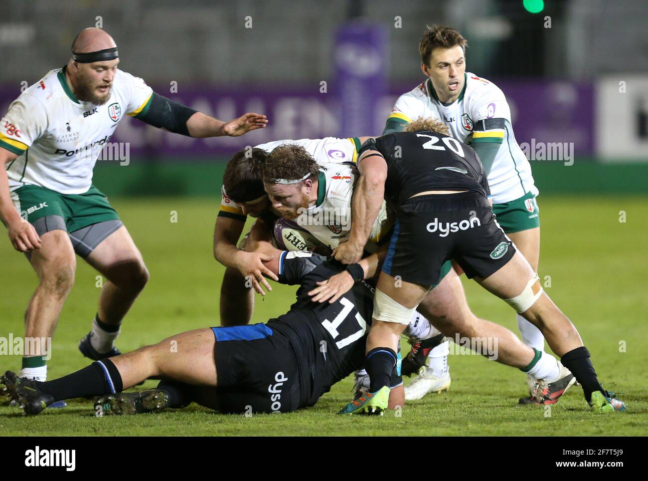 London Irish's Harry Elrington (centre) is tackled by Bath Rugby's Juan Schoeman (left) and Miles Reid (right) during the Challenge Cup, quarter final match at the Recreation Ground, Bath. Picture date: Friday April 9, 2021. Stock Photo