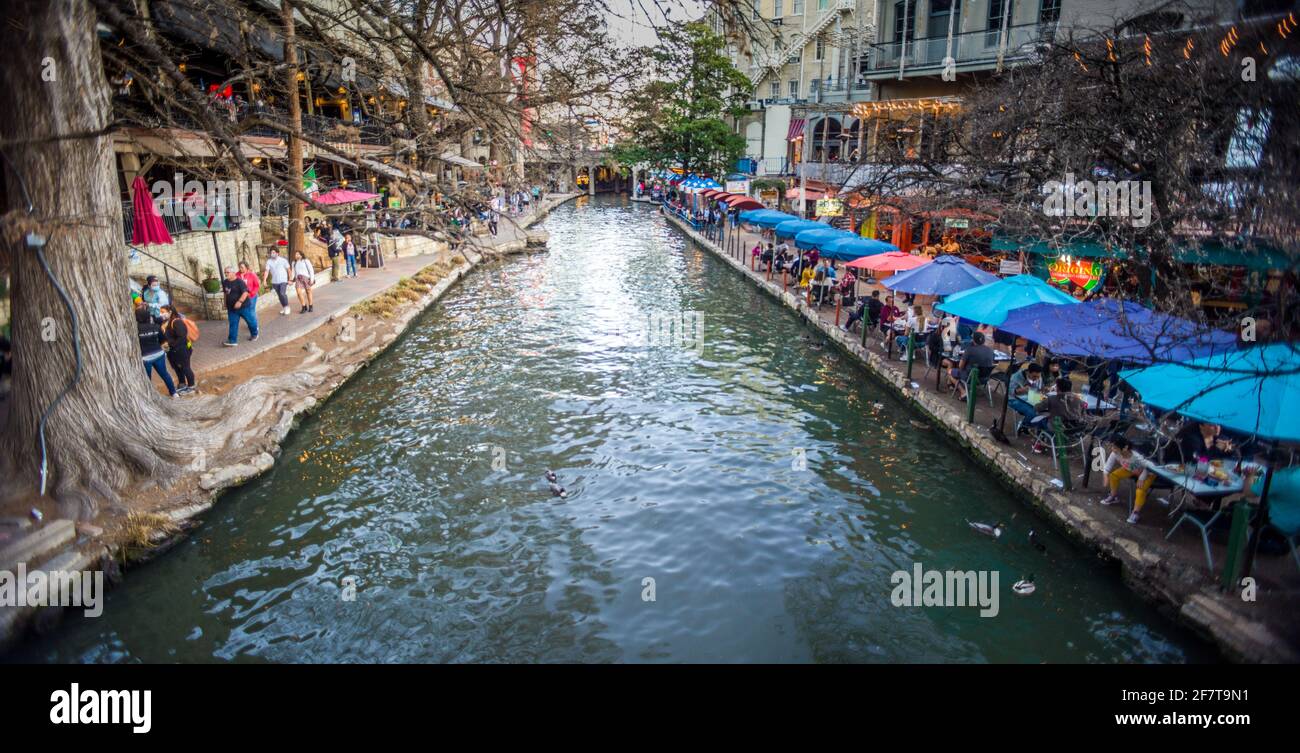 People eating outdoors and walking along the Riverwalk, San Antonio, TX Stock Photo