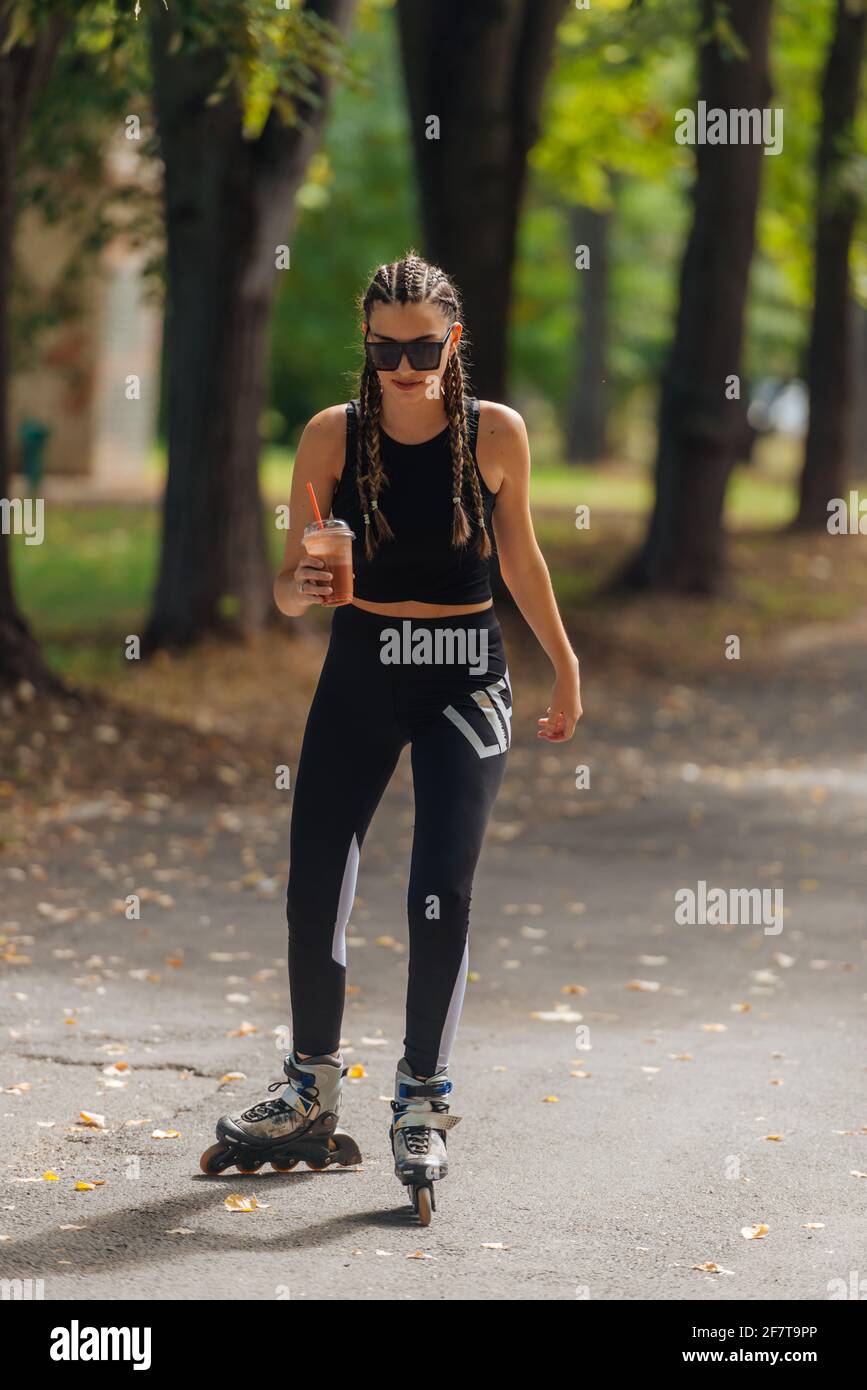 Hot athletic woman in sportswear rollerblading at the park in sunny weather  Stock Photo - Alamy