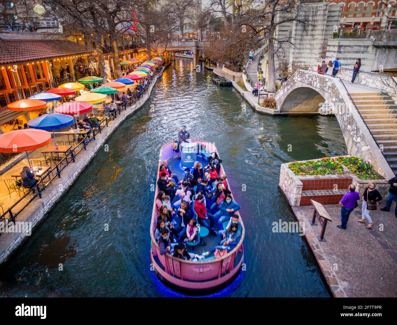 Boat ferries people along the Riverwalk, San Antonio, TX Stock Photo