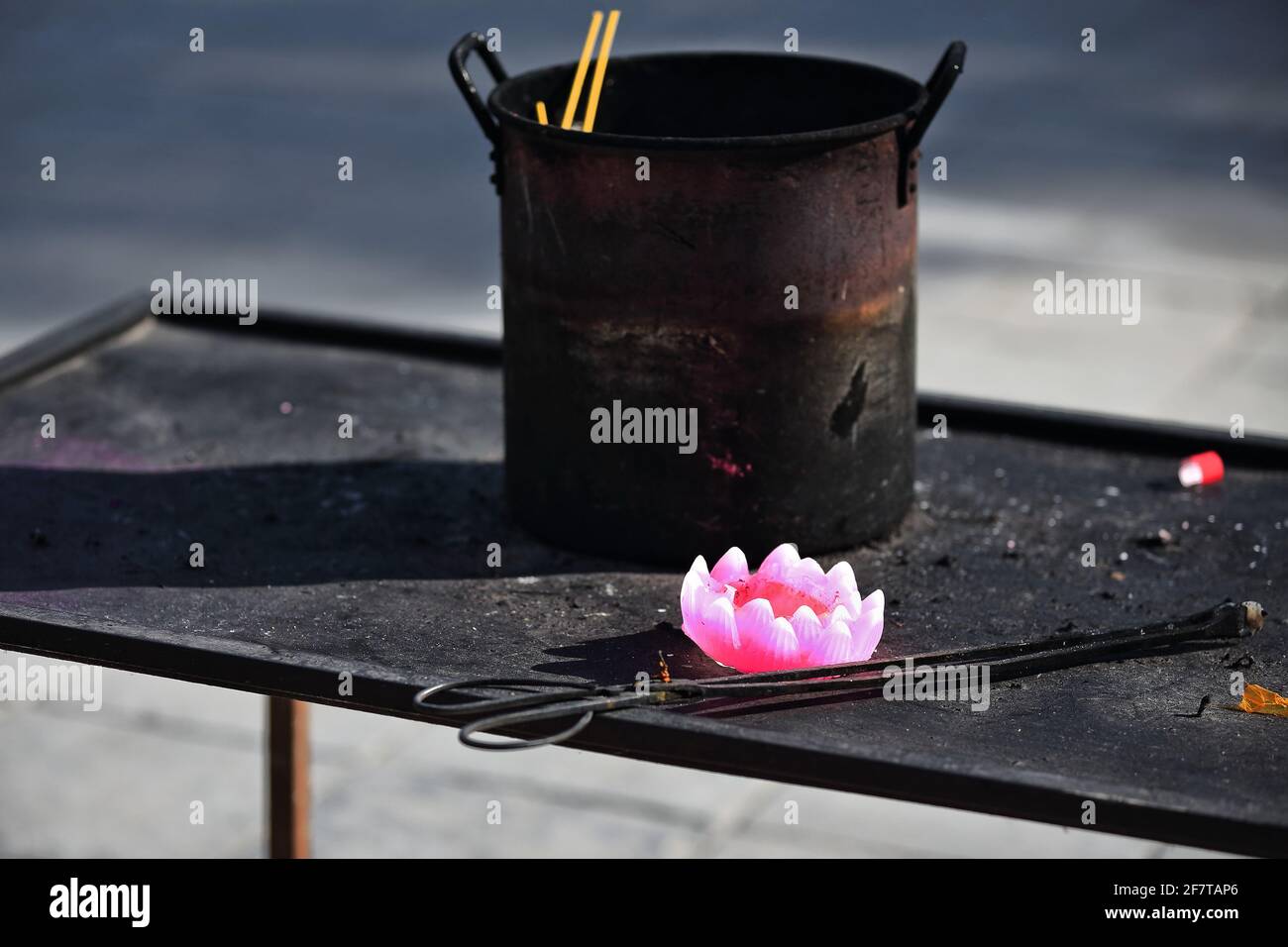 Pink lotus flower wax candle-rusty iron stock pot. Dafo Si-Zhangye-China-1284 Stock Photo