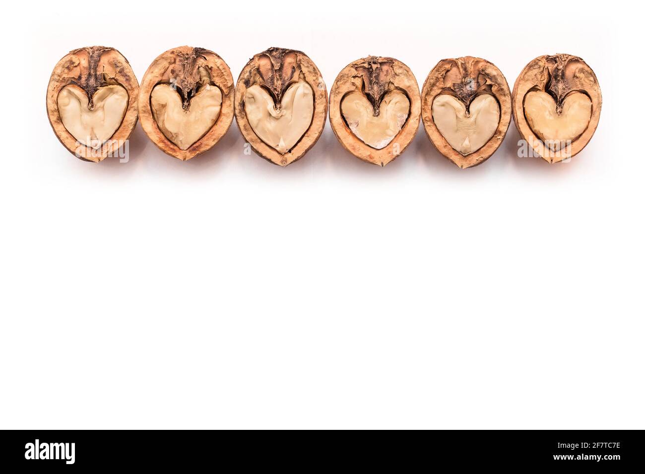 Walnut in a cut halves in the form of a heart isolated on a white background, copy space or mock up design. Stock Photo