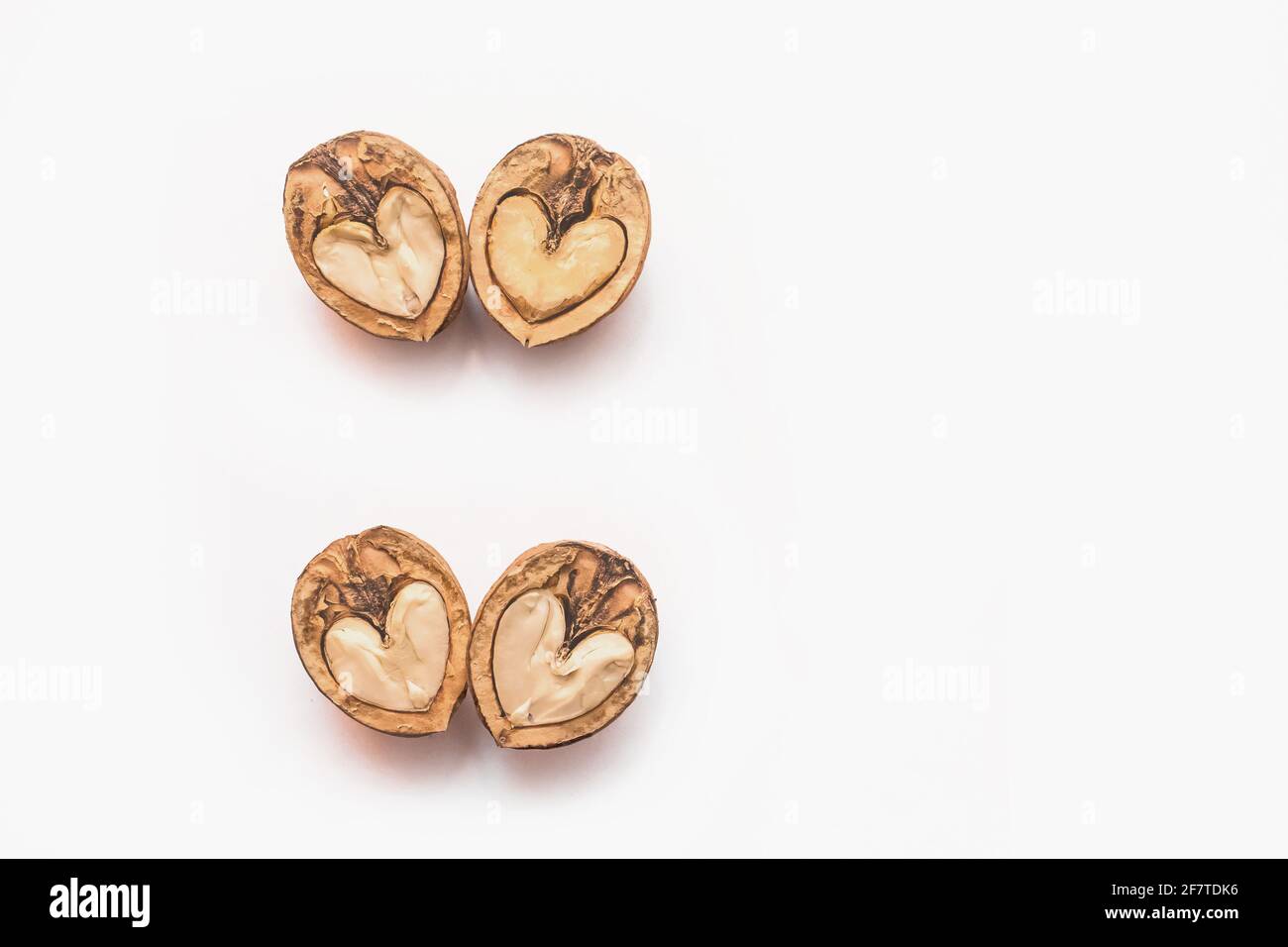 Halves of a walnut in the shape of a heart isolated on a white background. Stock Photo