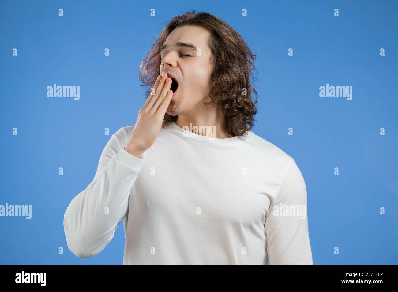 Tired sleepy man yawns. Lazy guy with long hairdo showing emotion of ...