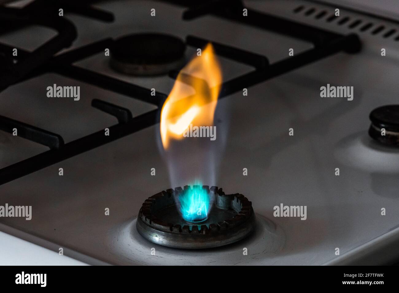 Gas burner with flame from a hole on a gas stove, closeup Stock Photo