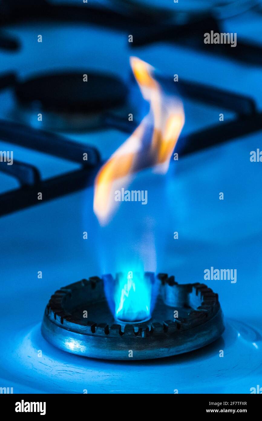 Gas burner with flame from a hole on a gas stove, closeup Stock Photo