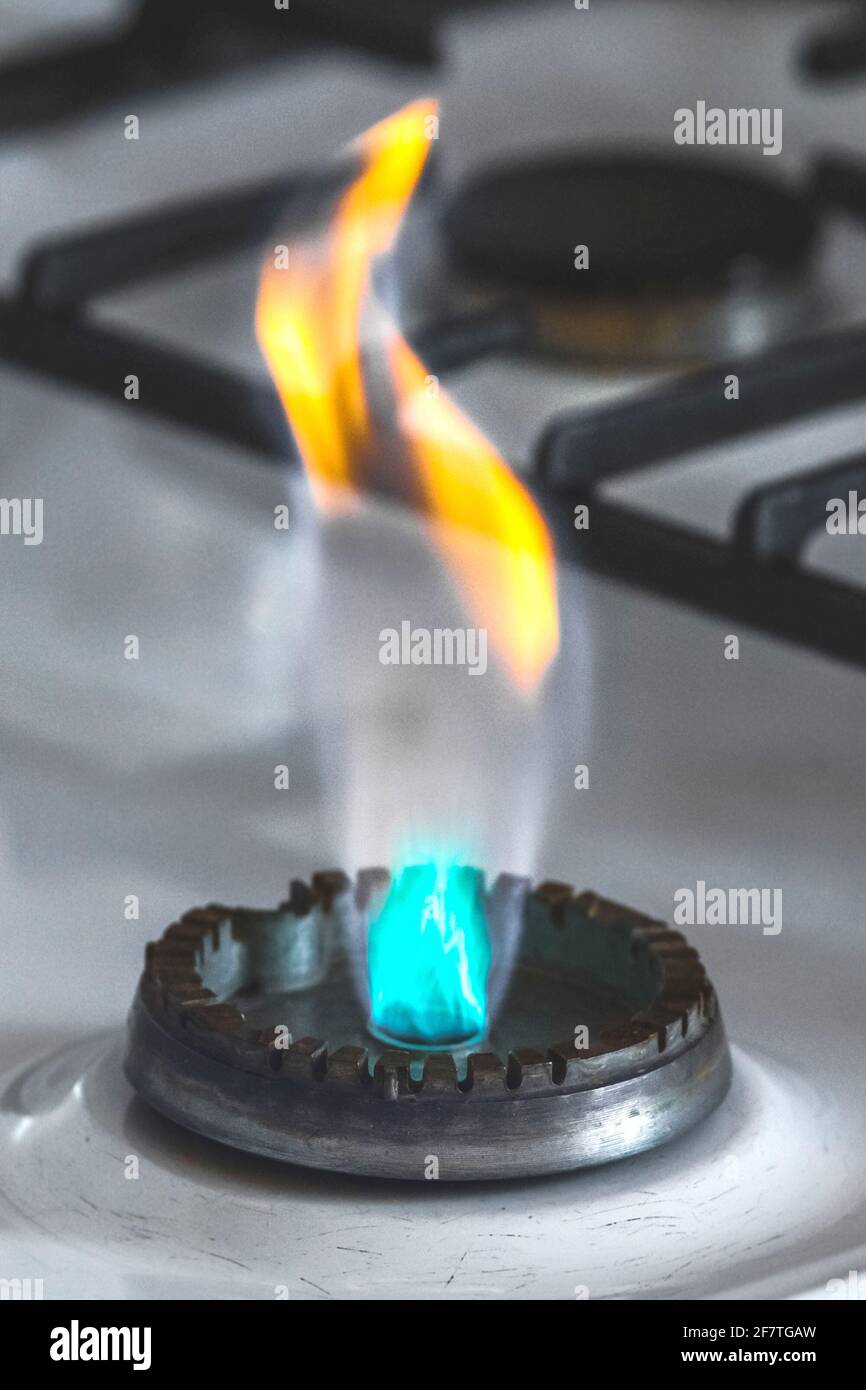 Gas burner with flame from a hole on a gas stove, closeup Stock Photo