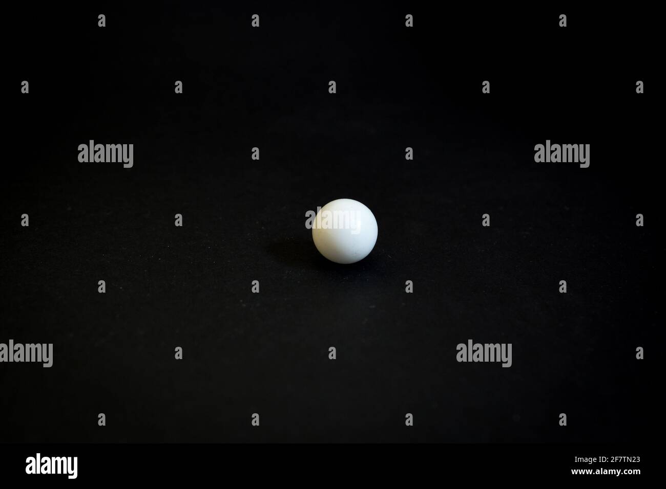 Closeup shot of a single white marble ball isolated on black background