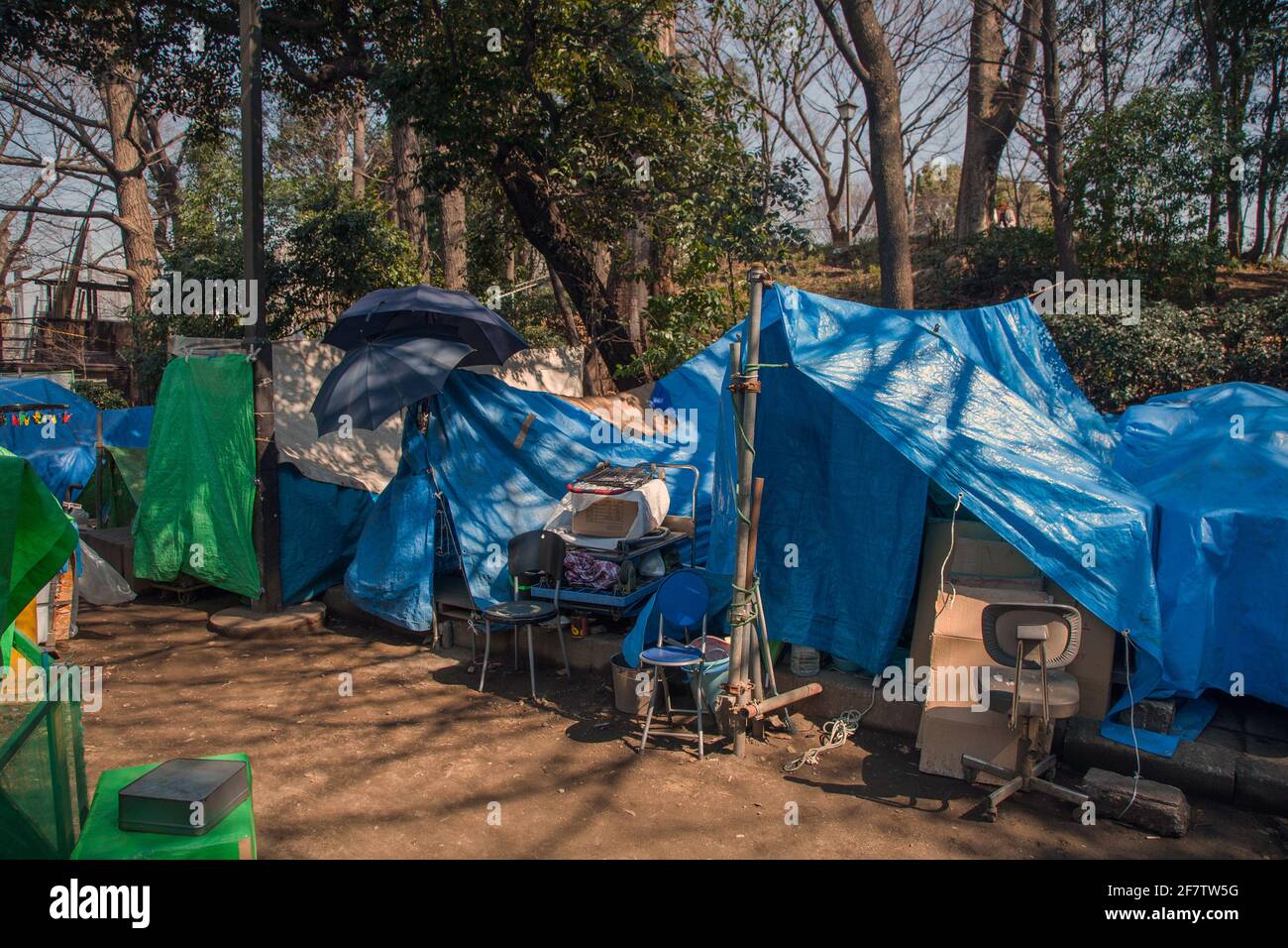 Area in Ueno Park where Japanese homeless people have stored their possessions under blue tarpaulin, Tokyo, Japan Stock Photo
