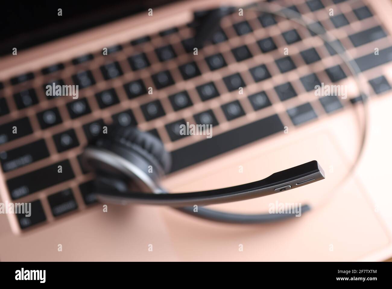 Black head set lying on laptop keyboard closeup Stock Photo