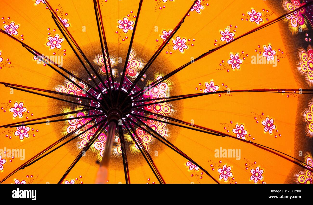 Low-angle shot of a yellow Japanese umbrella with flower patterns Stock Photo