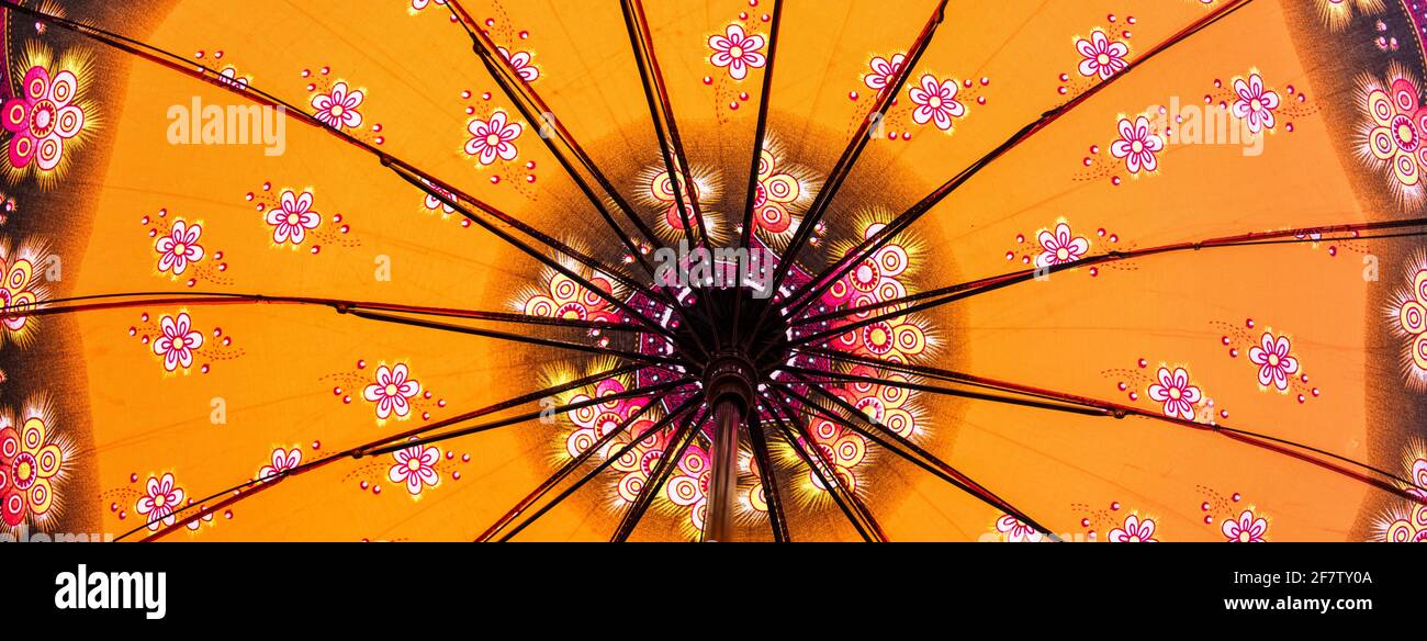 Low-angle shot of a yellow Japanese umbrella with flower patterns Stock Photo