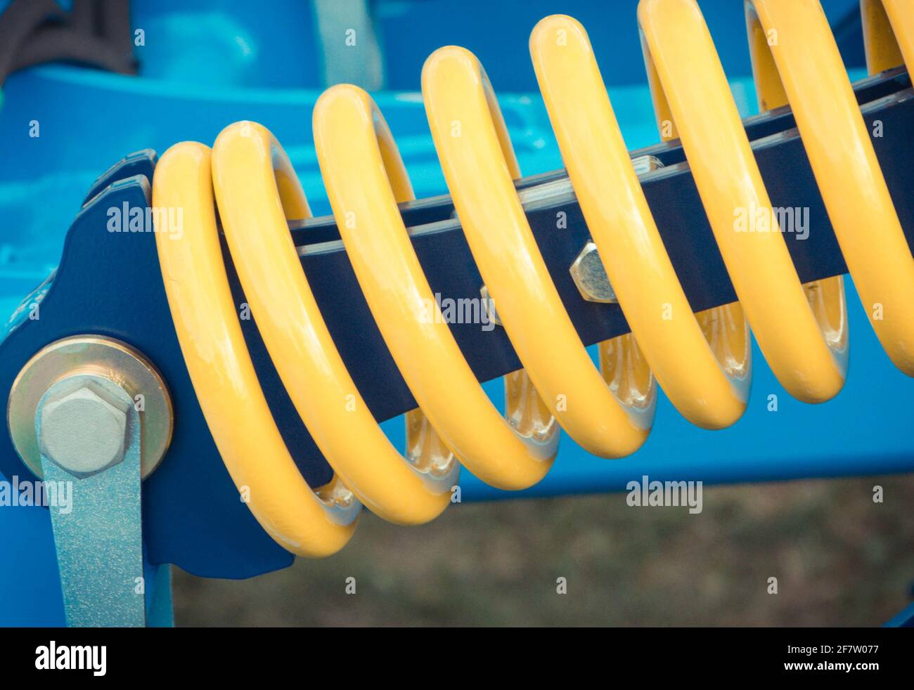 Hard Cycle Spring Hard spring made of steel. Part and detail of blue industrial or ...