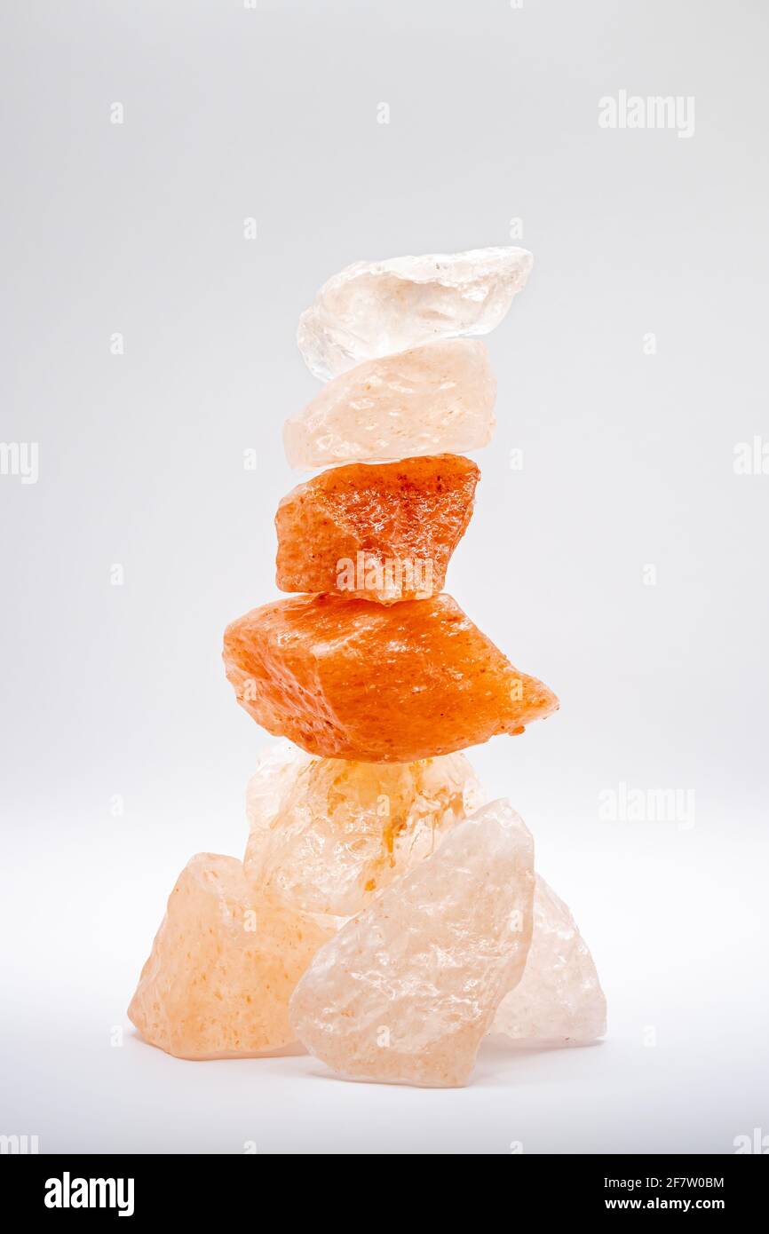 Large chunks of Himalayan sea salt are stacked on top of each other for peace and balance. Isolated against a white background. Stock Photo