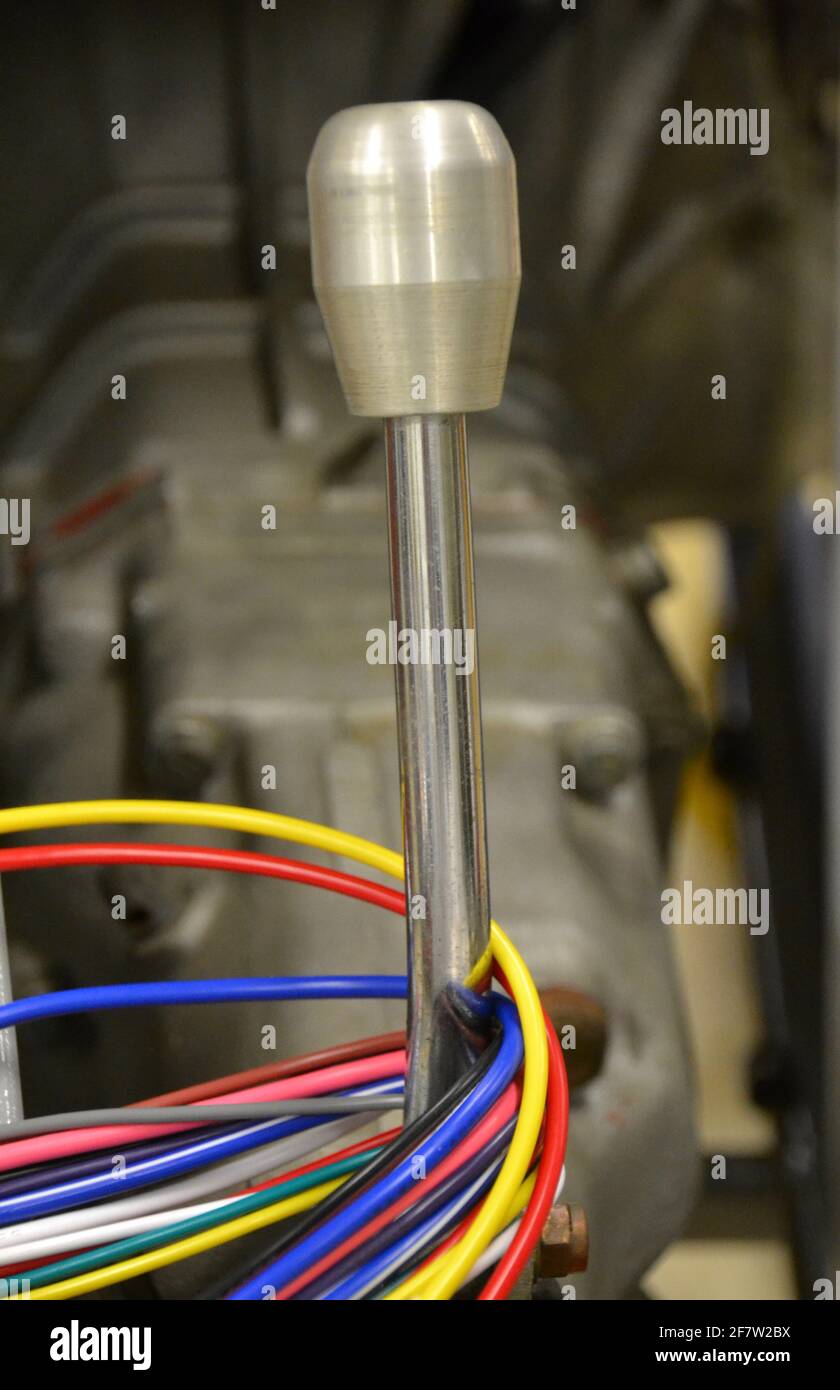 Interior chassis of a motor racing car with silver gear stick auto electrical wiring in many colours looped around it Stock Photo