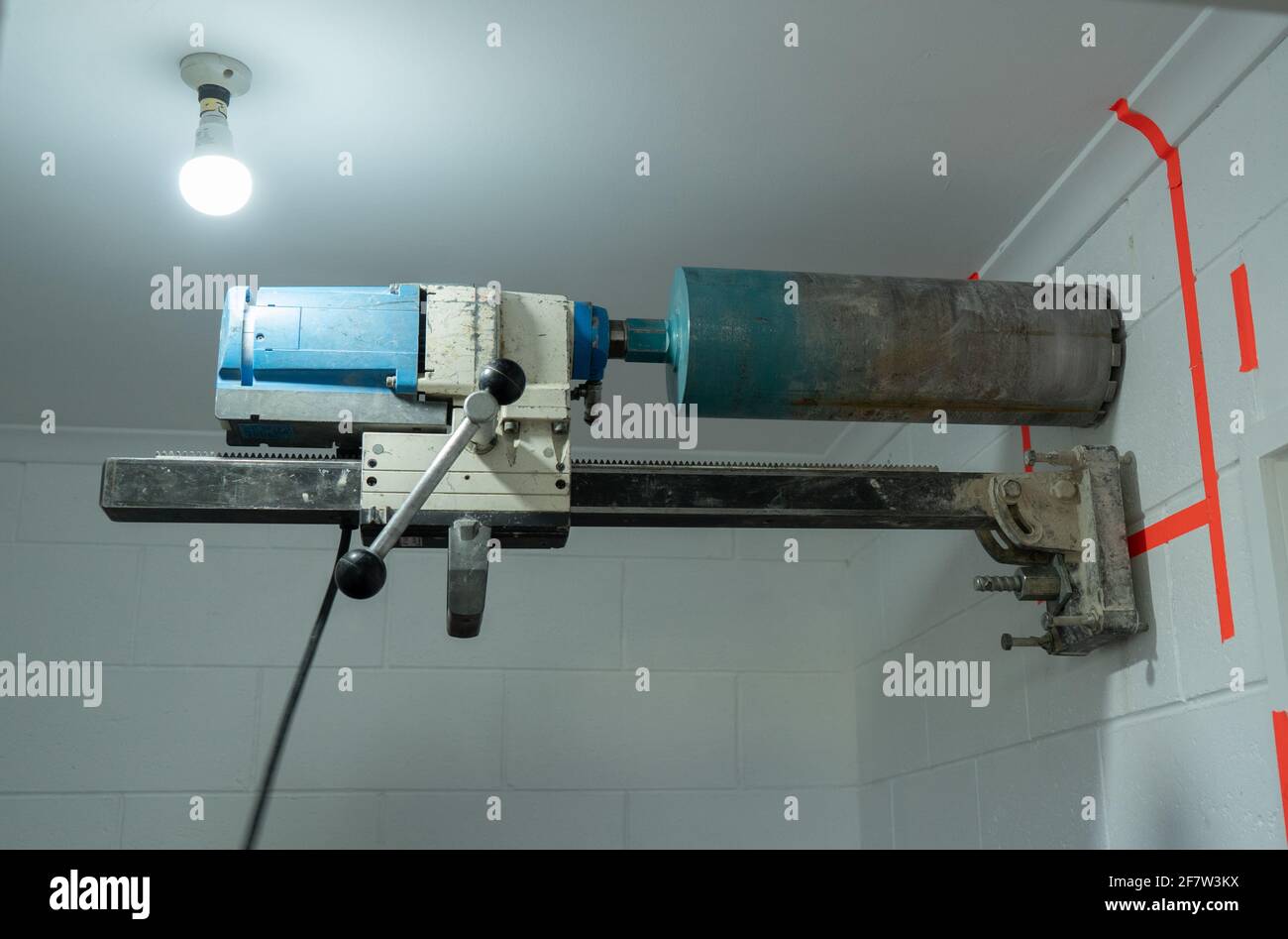 Concrete coring diamond cutting drill bolted to a white wall with an anchor bolt Stock Photo Alamy