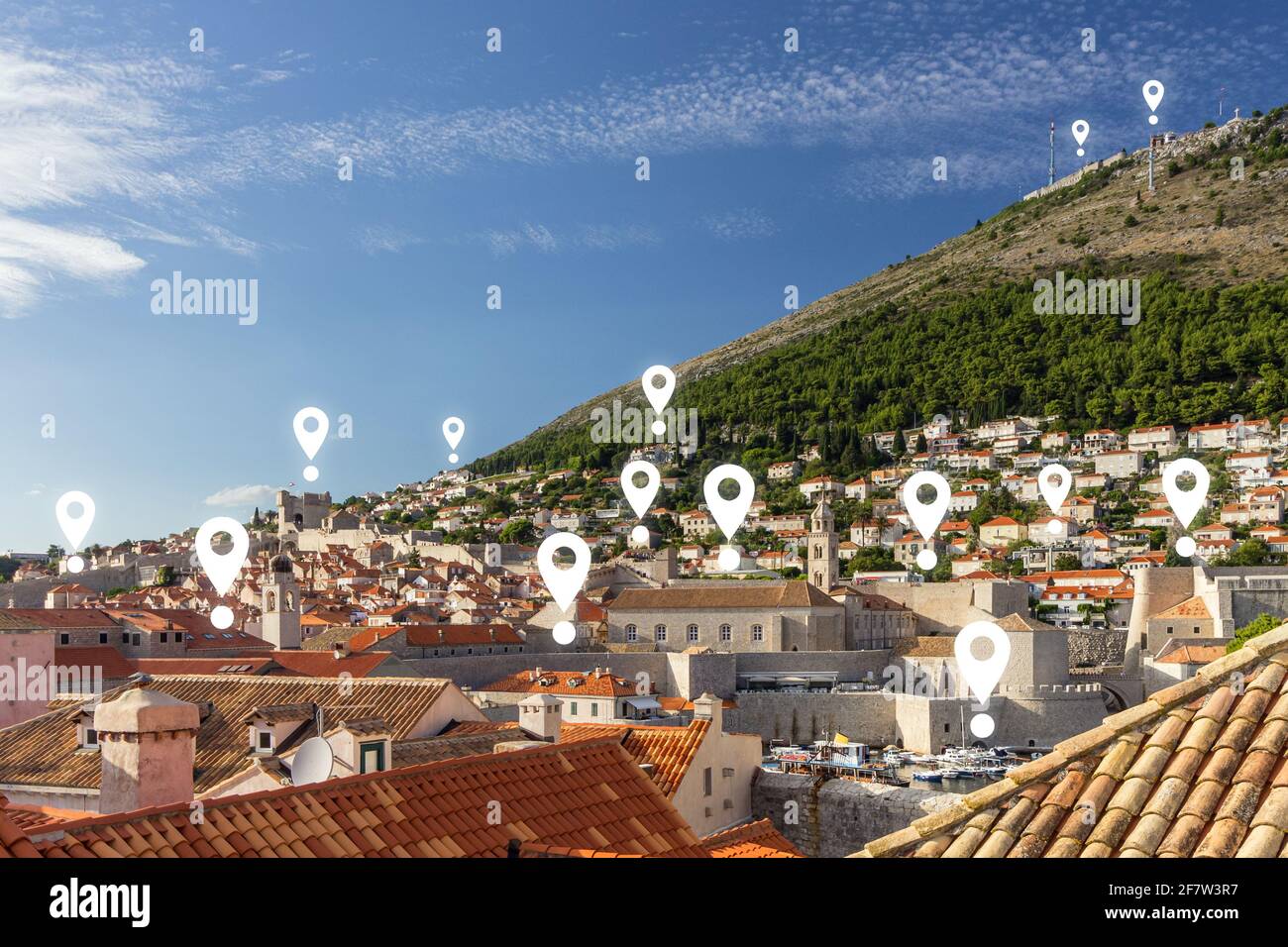 Map pin icons on Dubrovnik's cityscape. View of buildings at the Old Town and Mt. Srd in Dubrovnik, Croatia, on a sunny day. Stock Photo