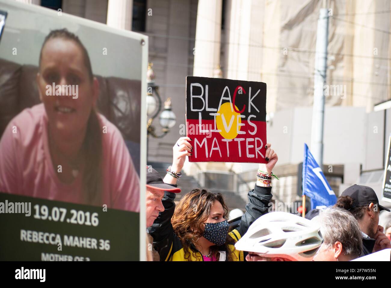 Melbourne, Australia. 10th April 2021. A protester holding a 'Black Lives Matter' sign next to a photo of an indigenous woman killed in police custody outside of Parliament as part of a national day of action to stop black deaths at the hands of police. 30 years after a royal commission into police brutality against indigenous people and yet nothing has changed. This follows the most recently documented case of police brutality towards an Aboriginal teenager in New South Wales earlier this month. Credit: Jay Kogler/Alamy Live News Stock Photo