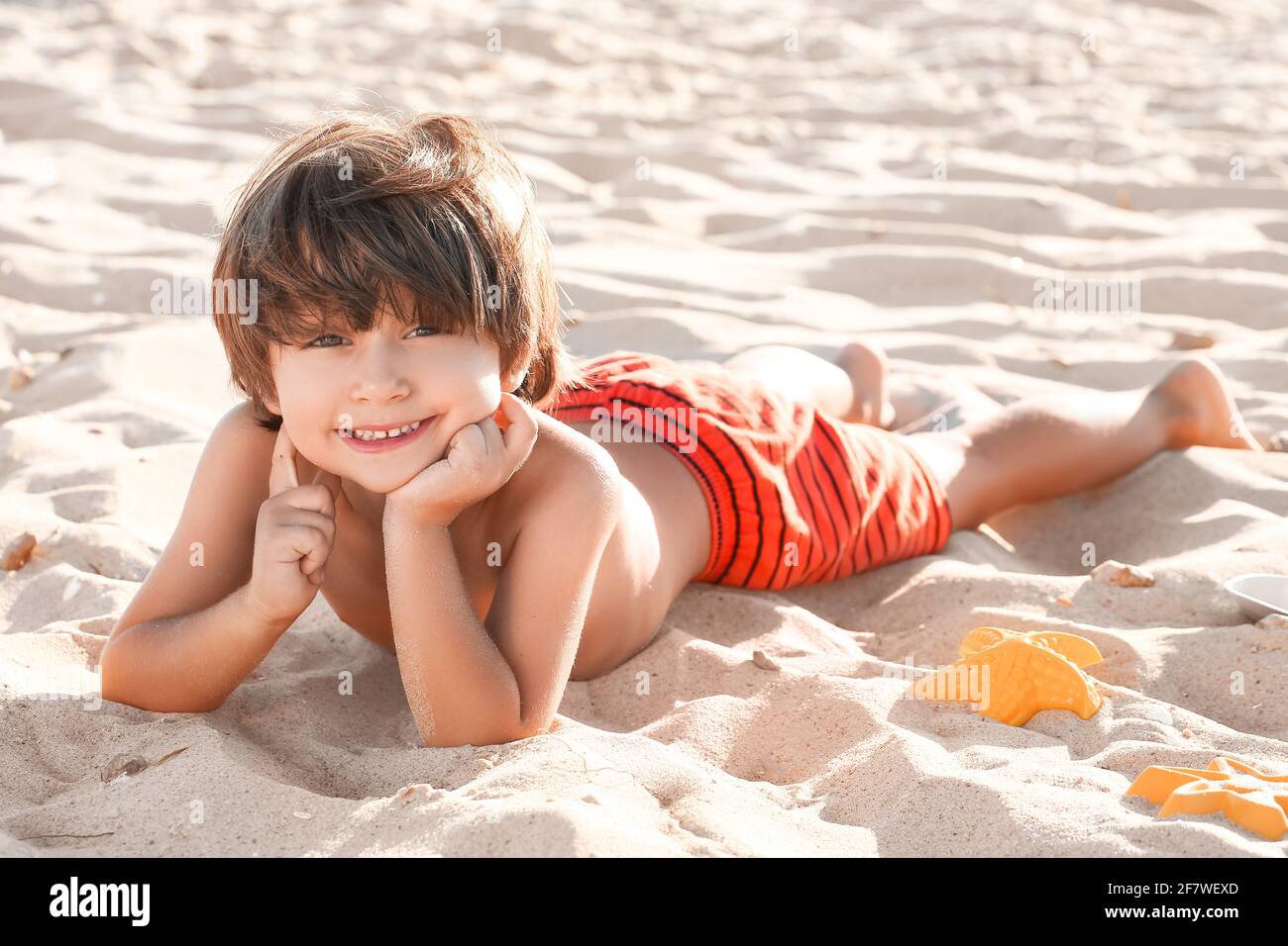 Cute little boy lying on sea beach Stock Photo - Alamy