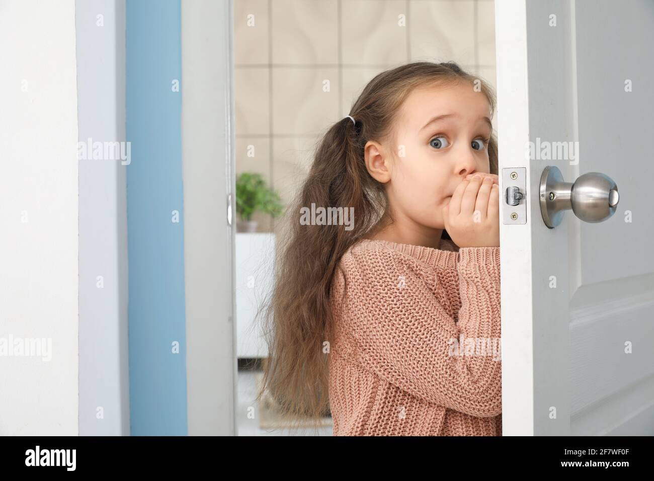 The Little Girl With A Scary Face Look At A Door Background
