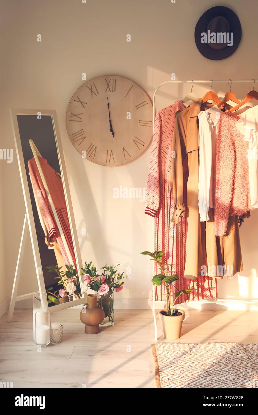 Rack with clothes in interior of modern room Stock Photo - Alamy