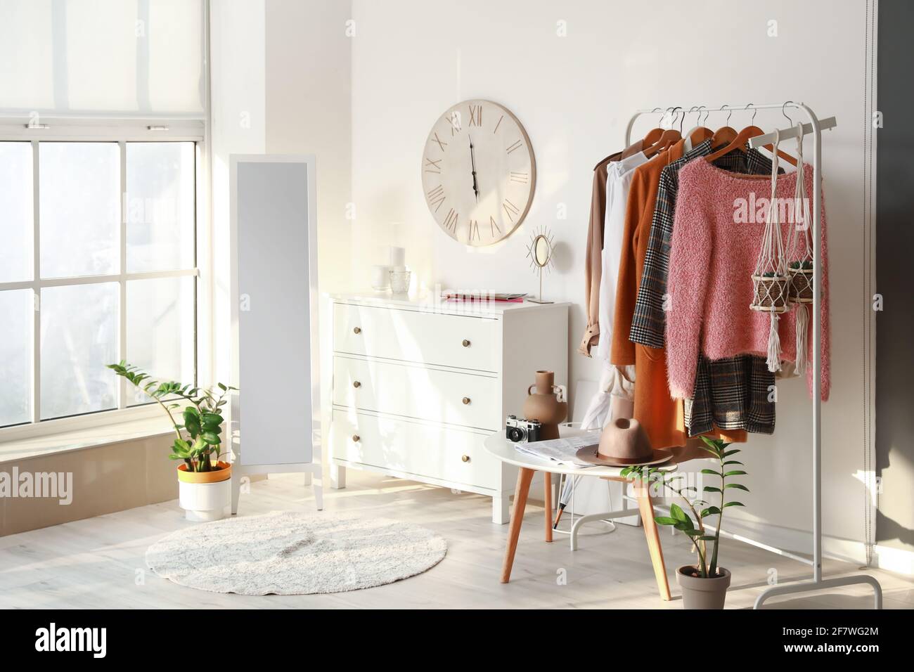 Rack with clothes in interior of modern room Stock Photo - Alamy