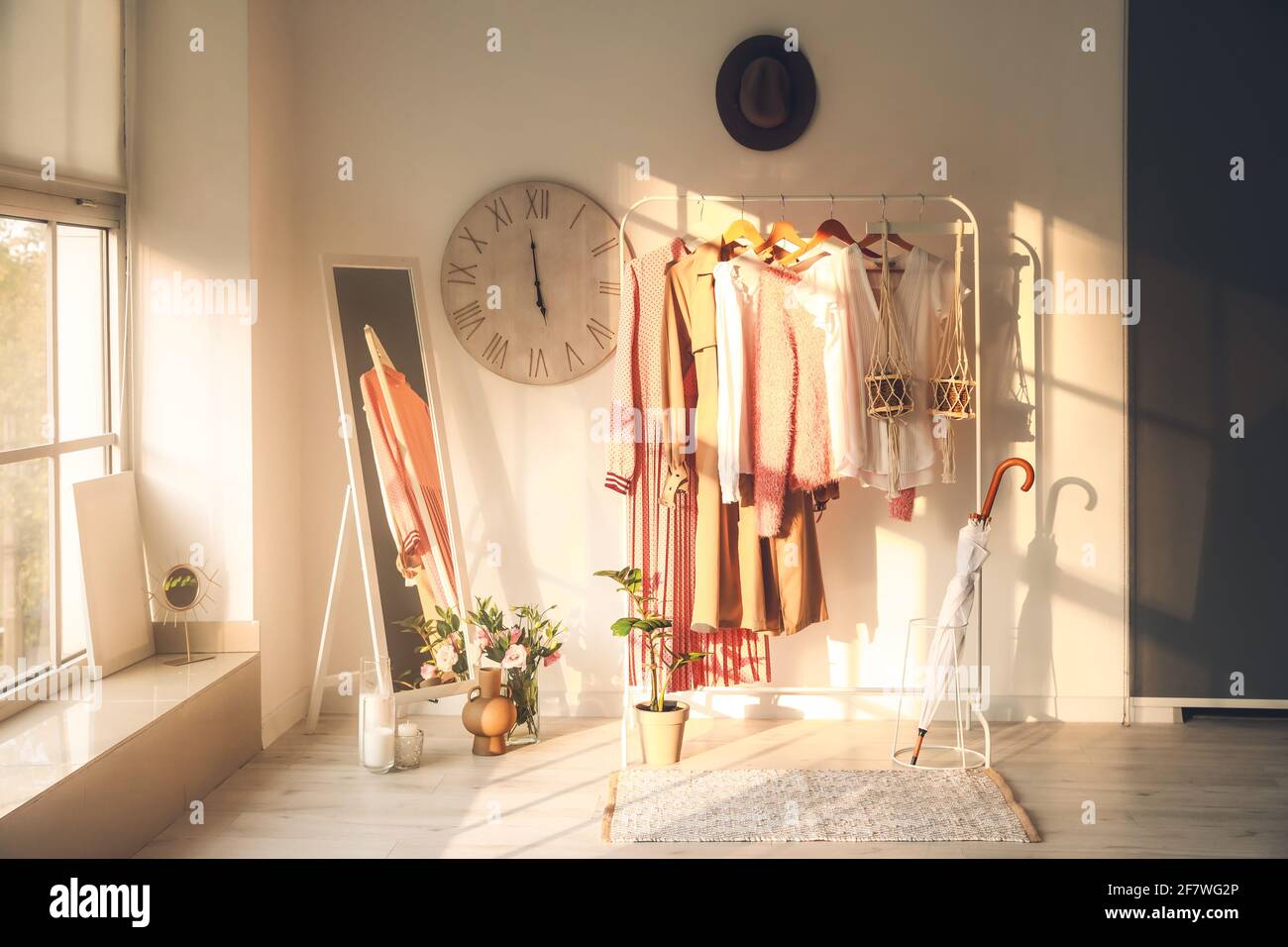 Rack with clothes in interior of modern room Stock Photo - Alamy