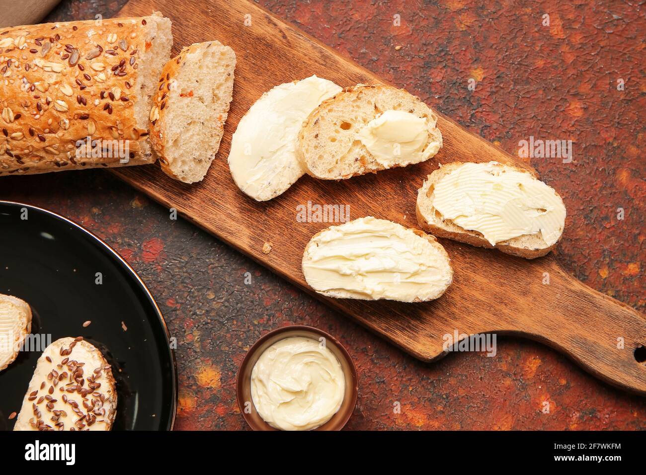 Slices of fresh bread with butter on grunge background Stock Photo - Alamy