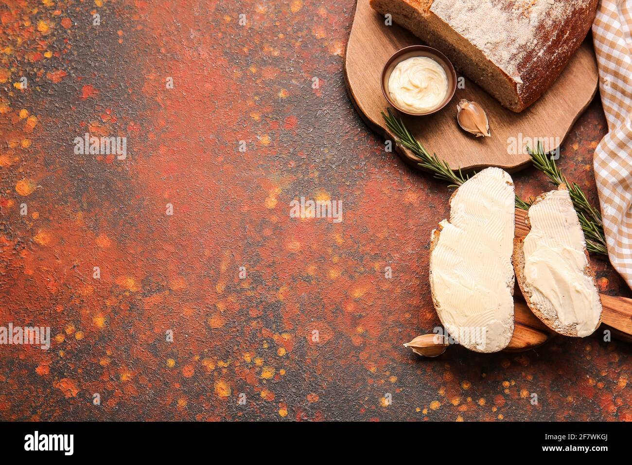 Slices of fresh bread with butter and rosemary on grunge background ...