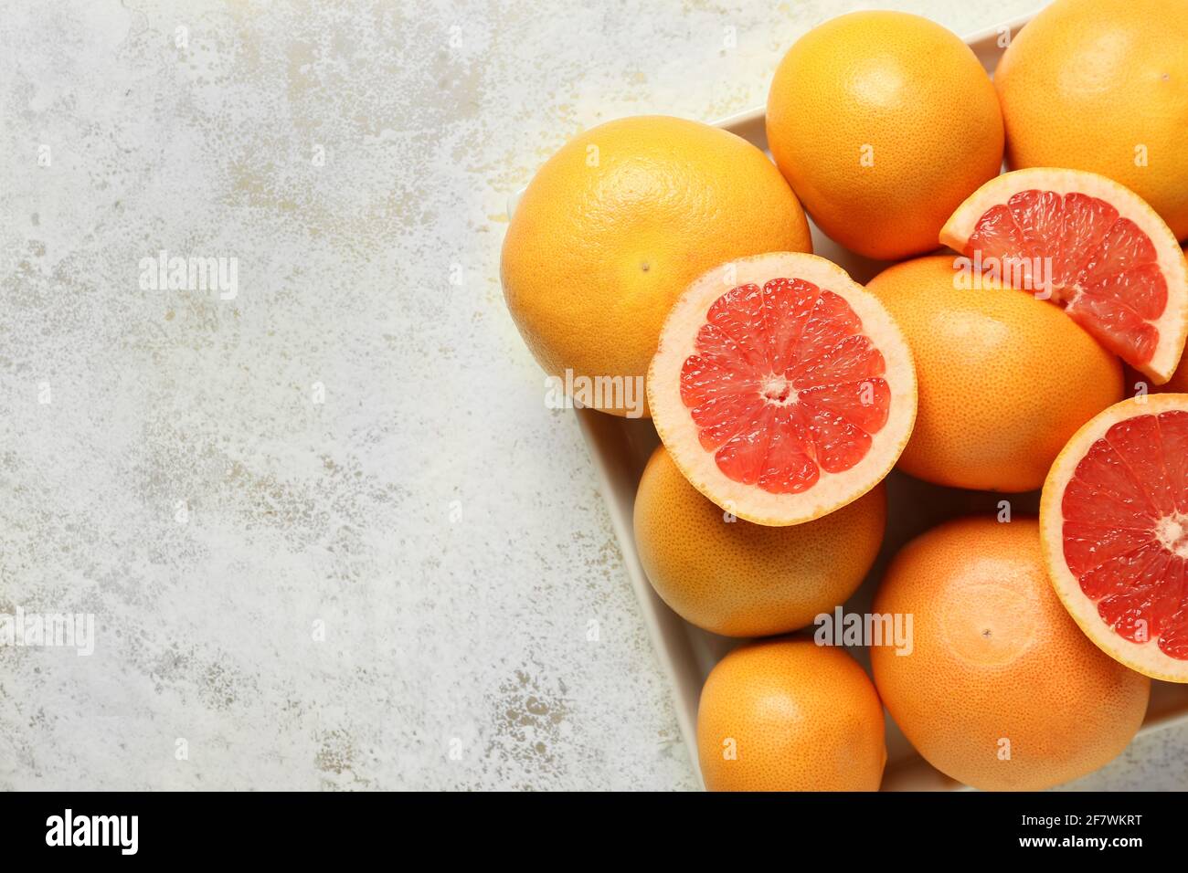 Box with ripe grapefruits on light background Stock Photo