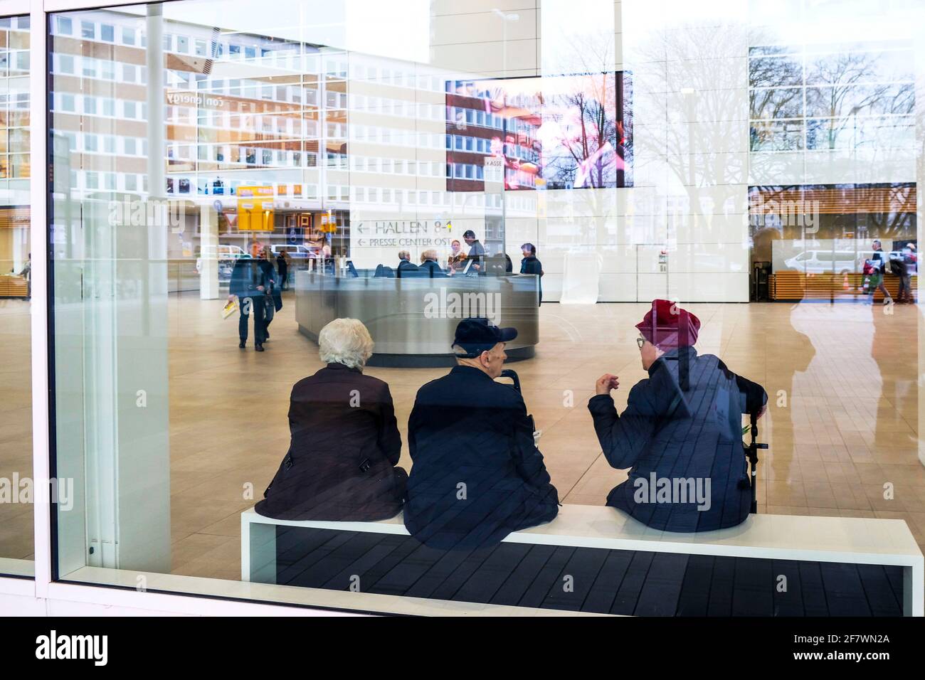 27.02.2020, Essen, Nordrhein-Westfalen, Deutschland - aeltere Messebesucher auf einer Bank in der neuen Eingangshalle Ost der Messe Essen waehrend der Stock Photo