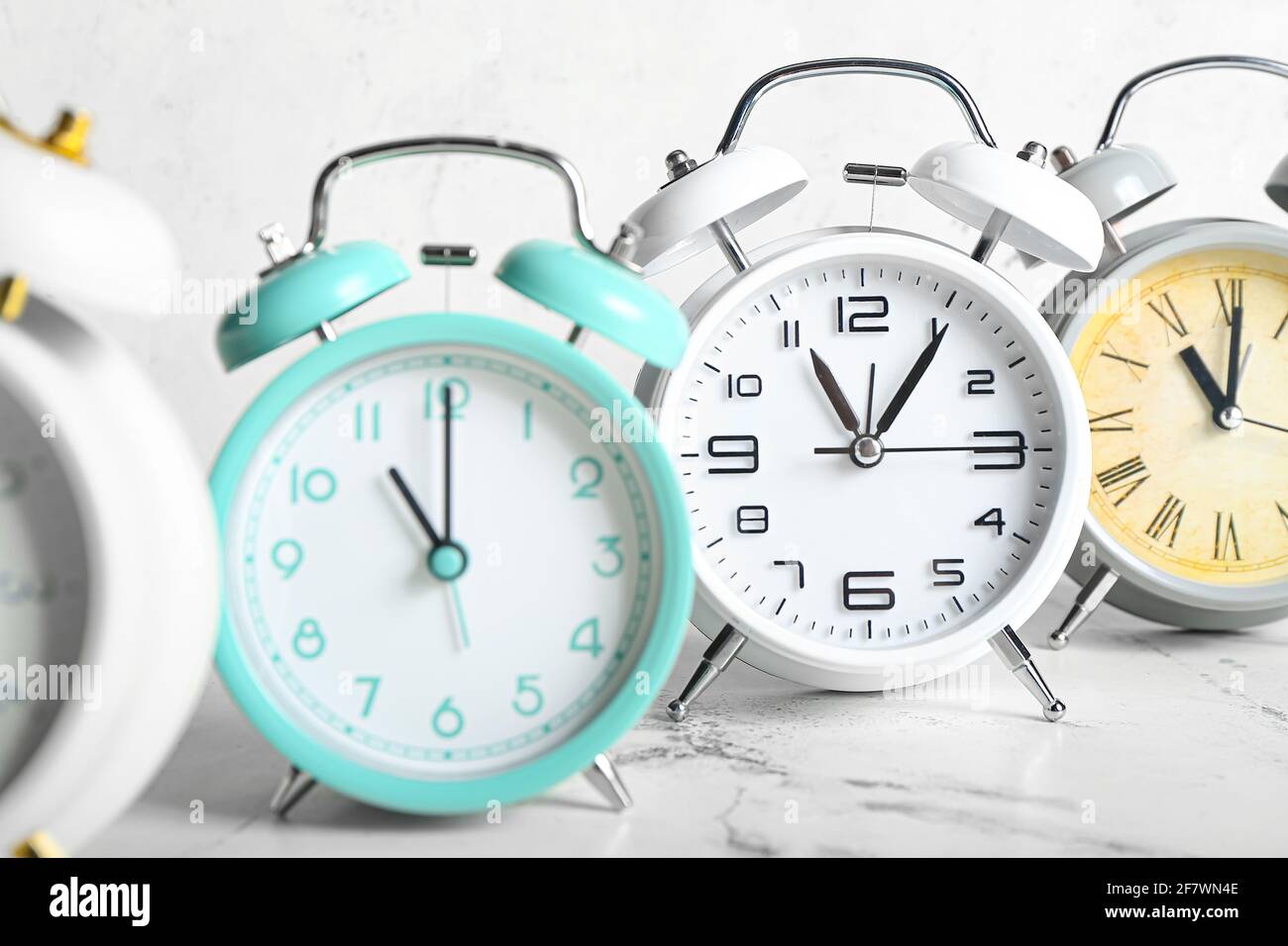 Different alarm clocks on light background, closeup Stock Photo
