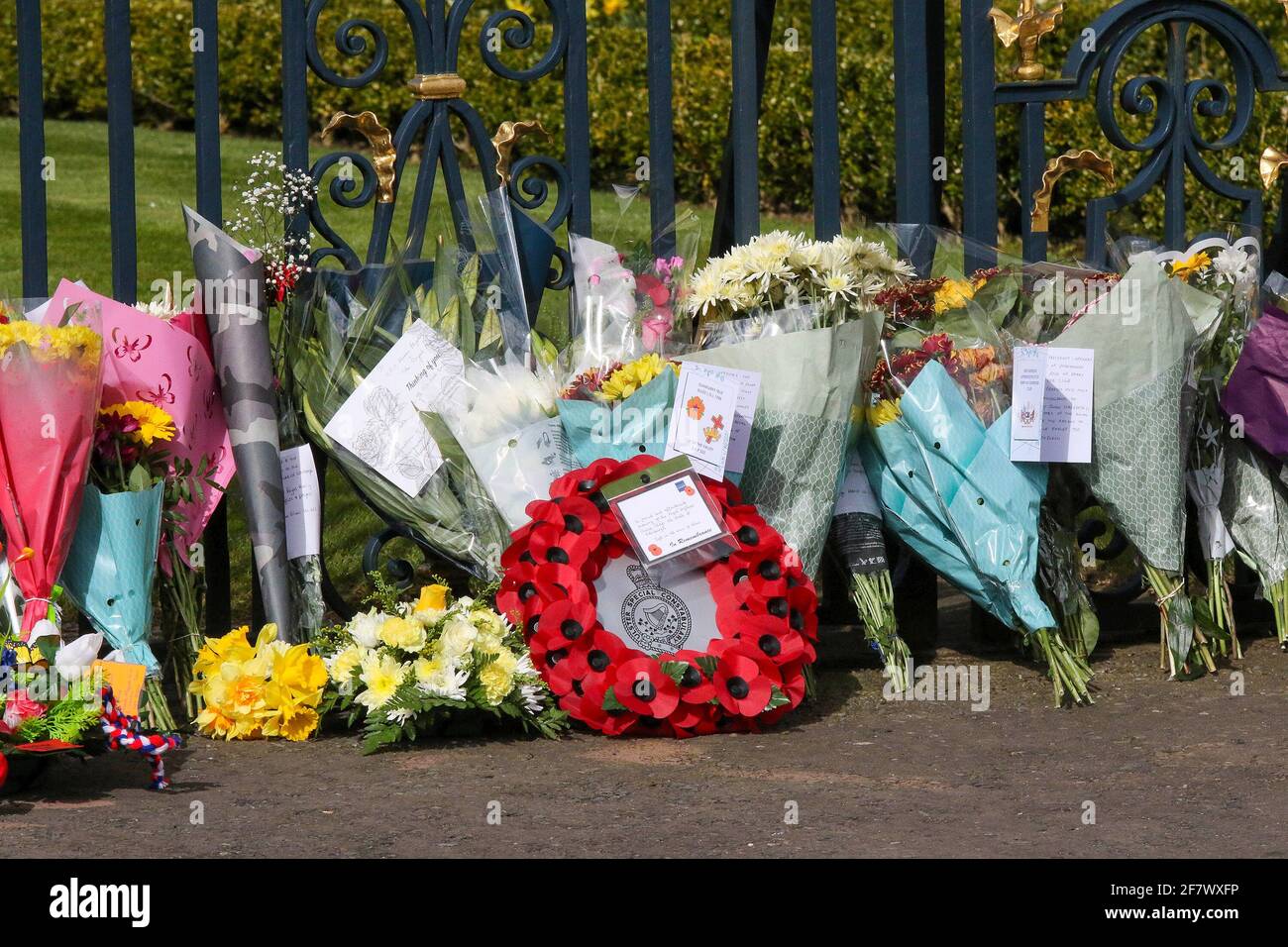 Hillsborough Castle, Hillsborough, County Down, Northern Ireland, UK. 10 April 2021. With the Union flag at half-mast, floral tributes have been left outside the gates of HM The Queen's official residence in Northern Ireland as the public mourn the loss of Prince Philip, Duke of Edinburgh, who died yesterday. Credit: David Hunter/Alamy Live News. Stock Photo